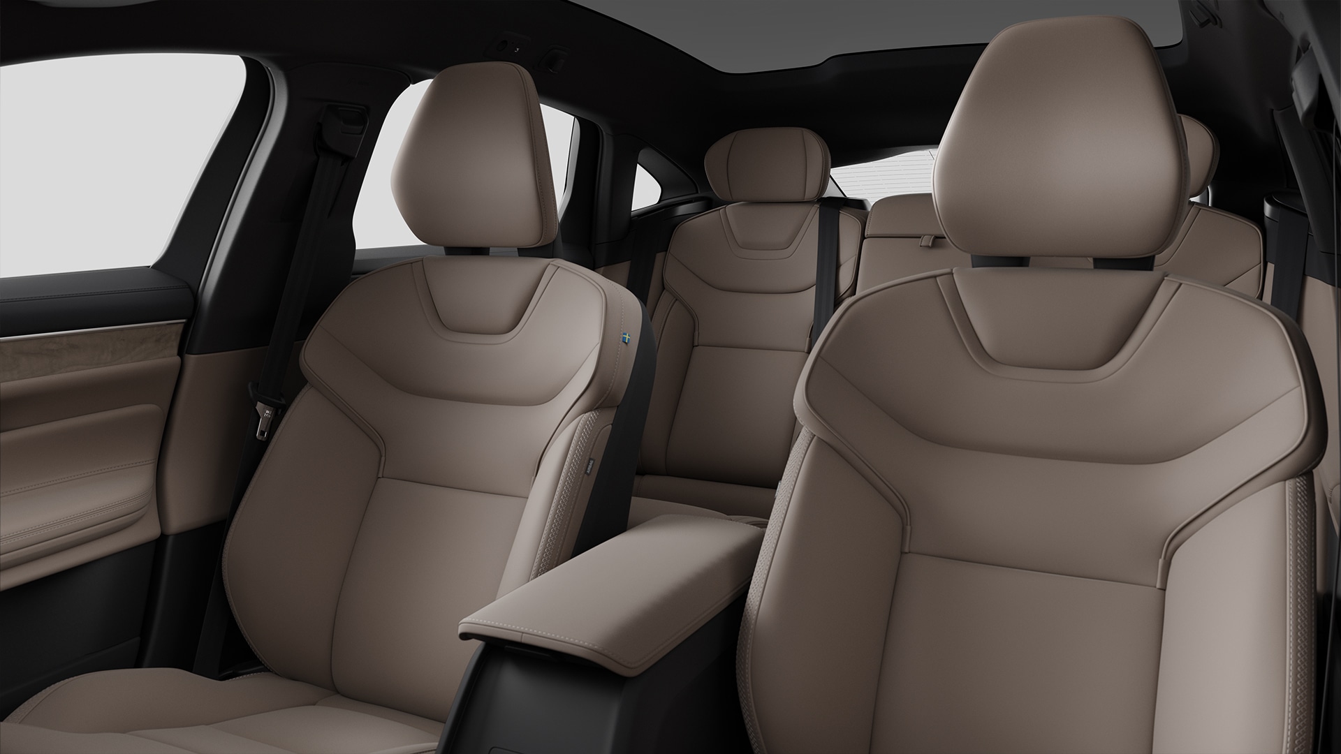 Interiörvy av ett Volvo-fordon som visar beige lädersäten fram och bak med modern design och sömmar.