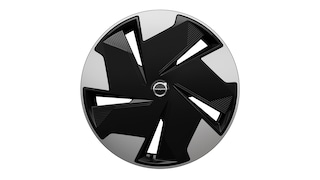 Close-up van een Volvo-wieldop met een modern geometrisch ontwerp in zwart-zilver en het Volvo-logo in het midden.