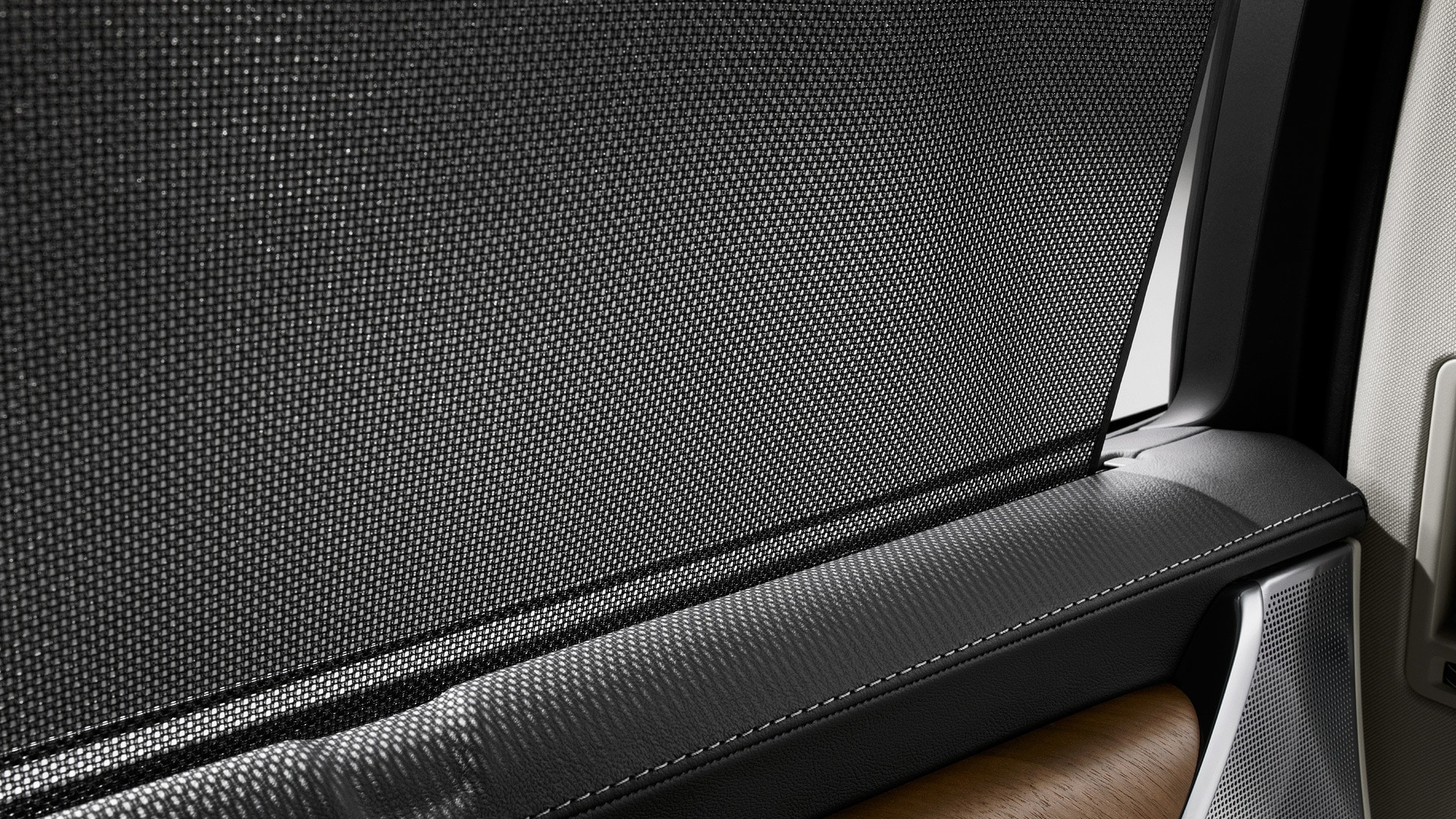 Zbliżenie na osłonę przeciwsłoneczną tylnych drzwi samochodu Volvo zintegrowaną z szybą