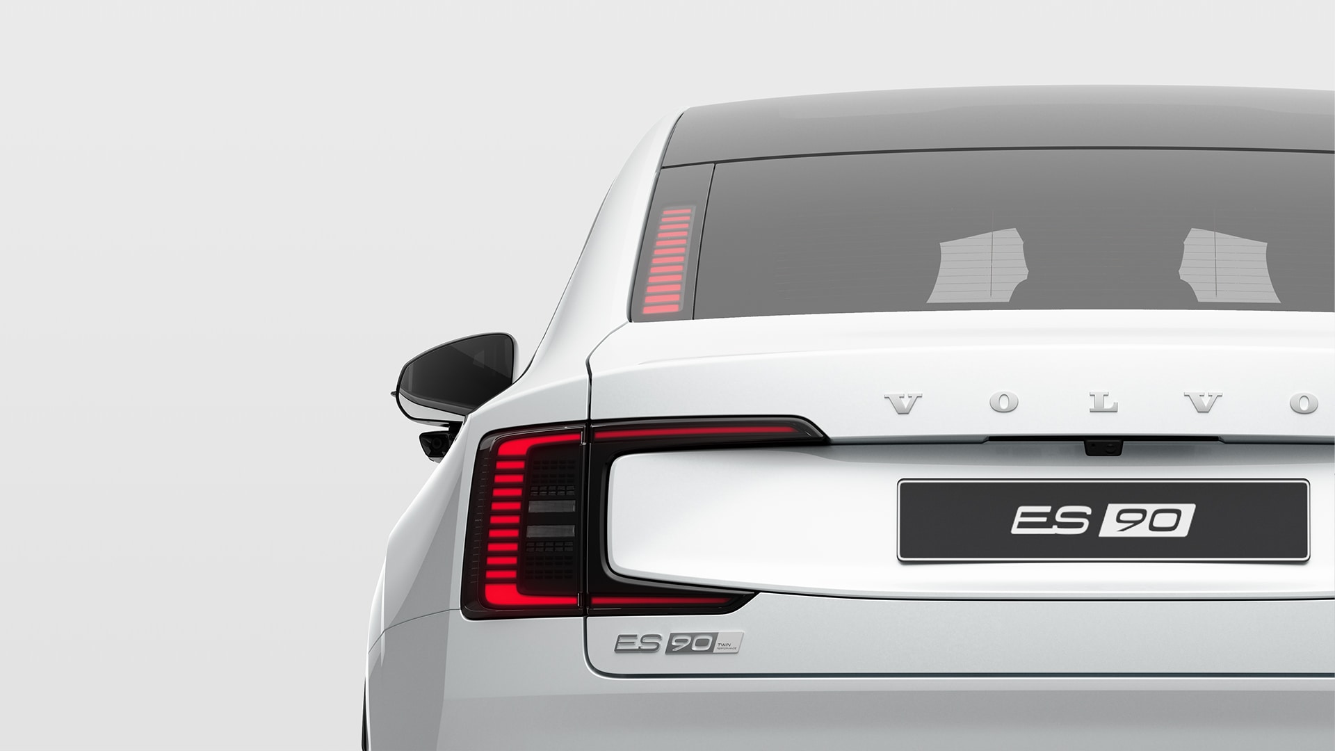 Vista trasera de un Volvo ES90 blanco, en la que destacan las luces traseras, el emblema del modelo y las letras Volvo.